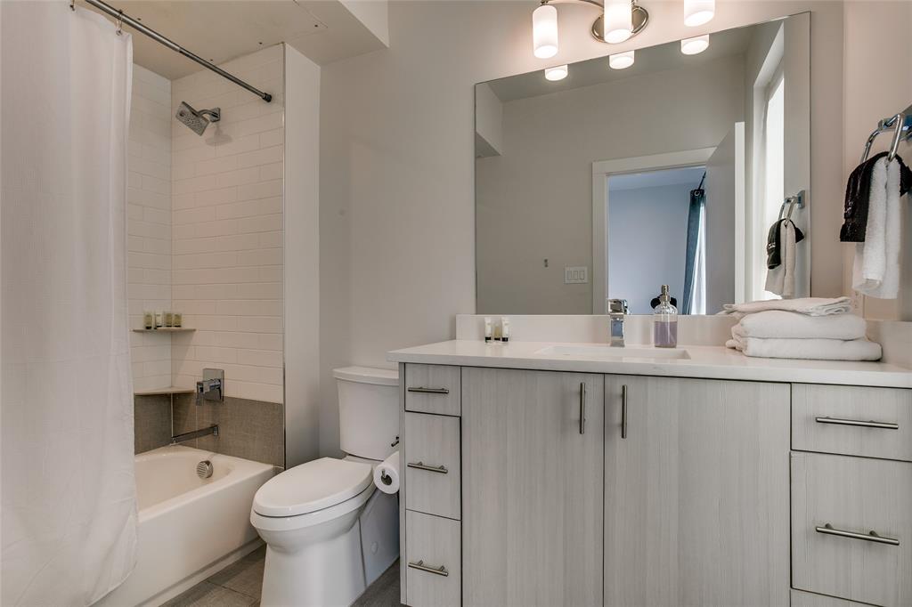 410 Melba Street, Unit 2 Dallas, TX 75208 - Photo 30 of 40 a bathroom with a toilet a sink a mirror a bathtub and vanity