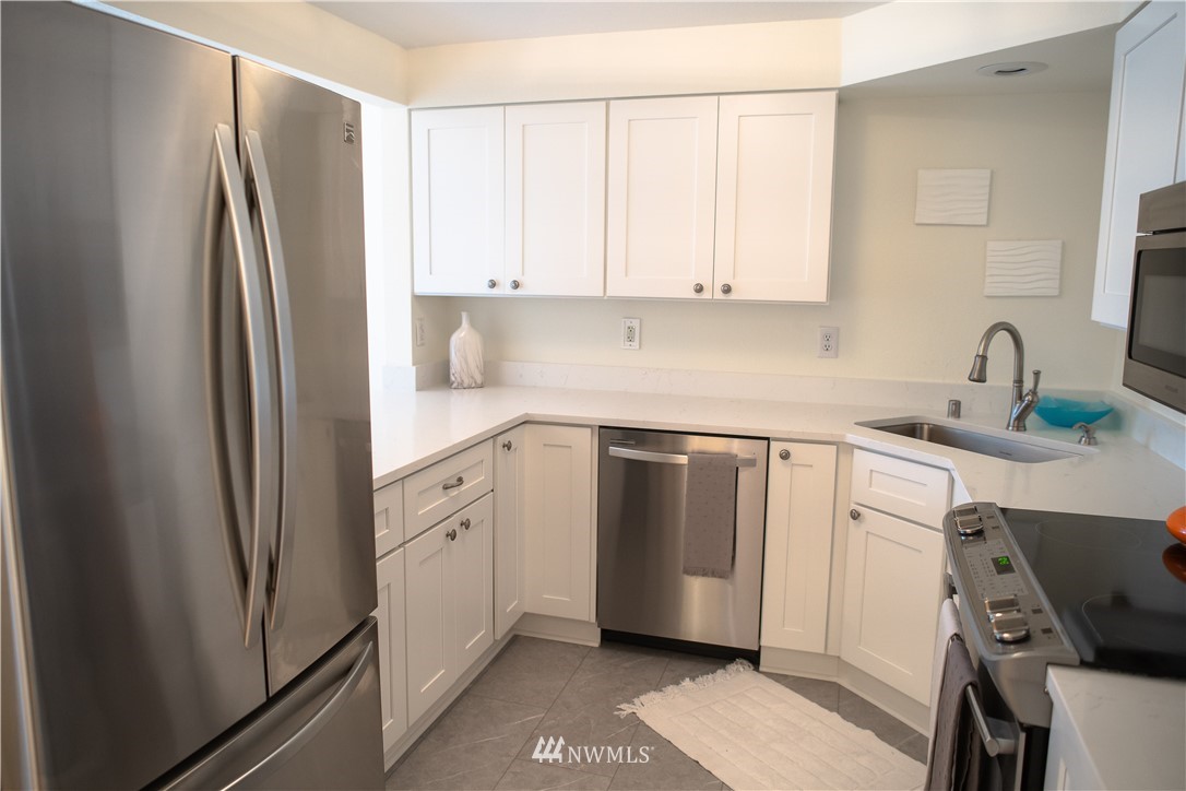 3733 Waller Road East, Unit 301 Tacoma, WA 98443 - Photo 10 of 17 a kitchen with a refrigerator sink and cabinets