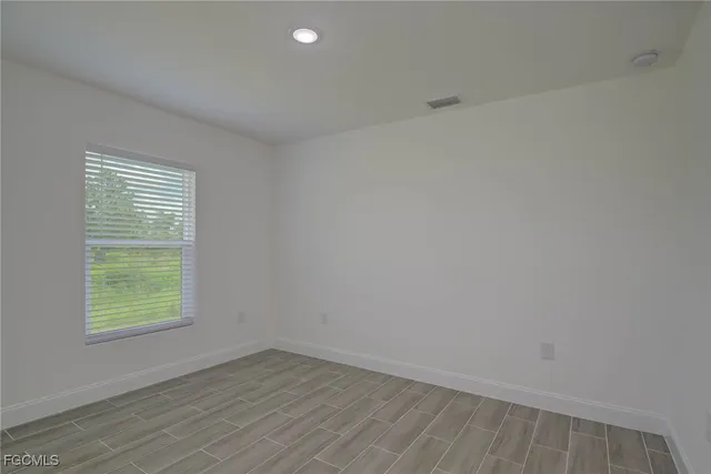 a view of a house with brick walls and a yard with plants