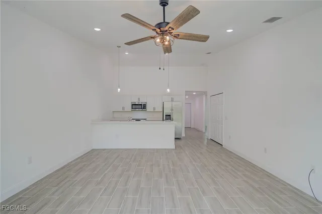 a kitchen that has a refrigerator a sink and wooden floor