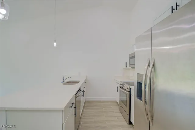 a kitchen with stainless steel appliances a sink a stove a microwave and refrigerator