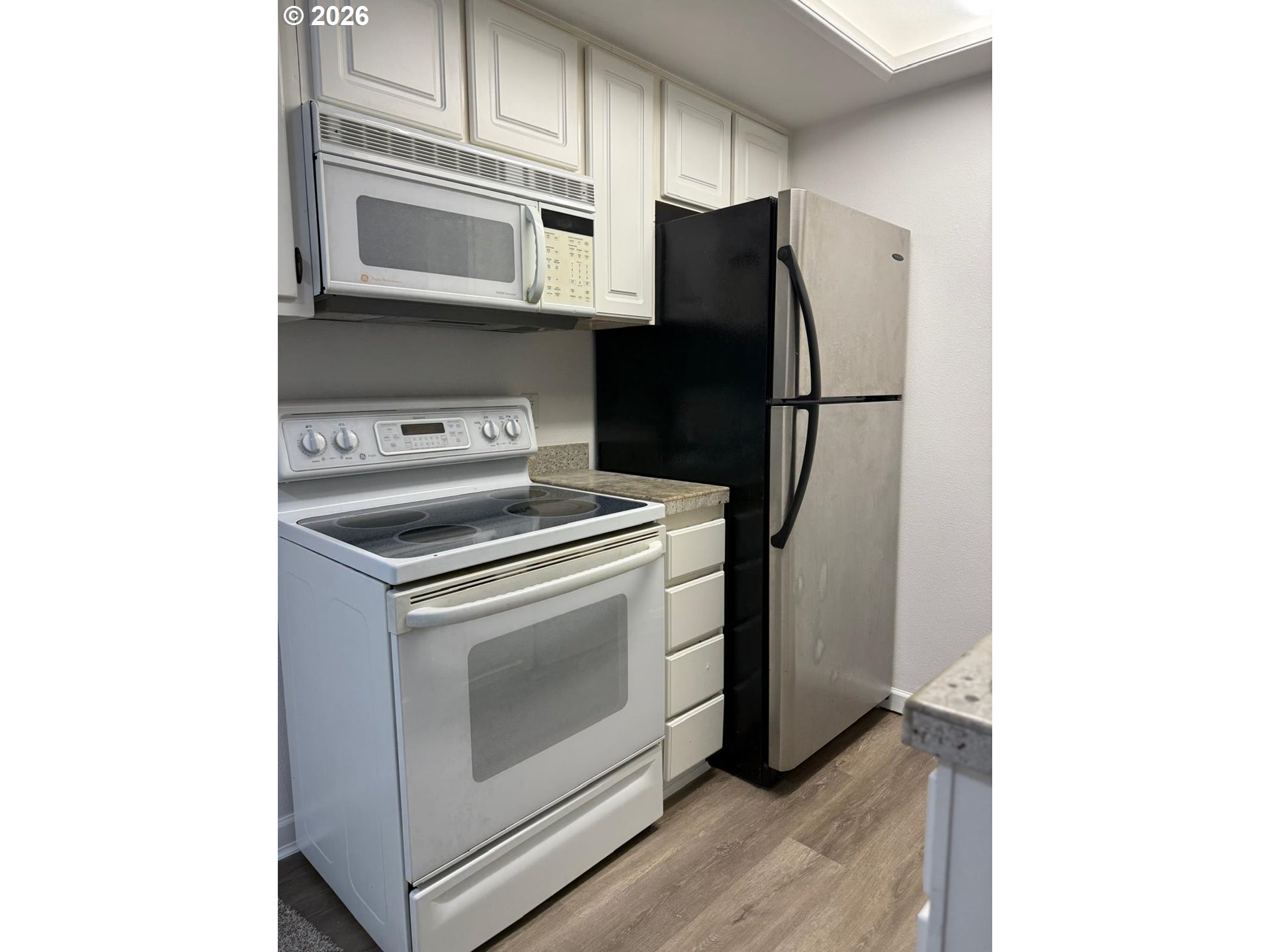 9987 Southeast Talbert Street Clackamas, OR 97015 - Photo 7 of 14 a kitchen with stainless steel appliances a stove microwave and refrigerator