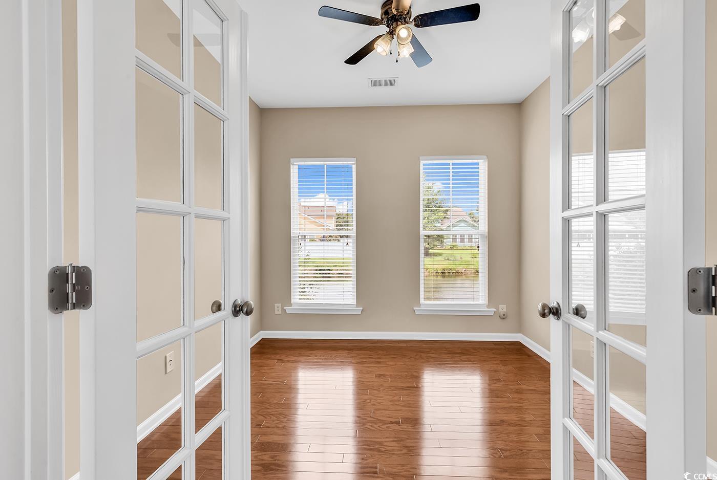 126 Dreamland Drive Murrells Inlet, SC 29576 - Photo 14 of 40 Empty room with french doors, wood finished floors, baseboards, and a ceiling fan