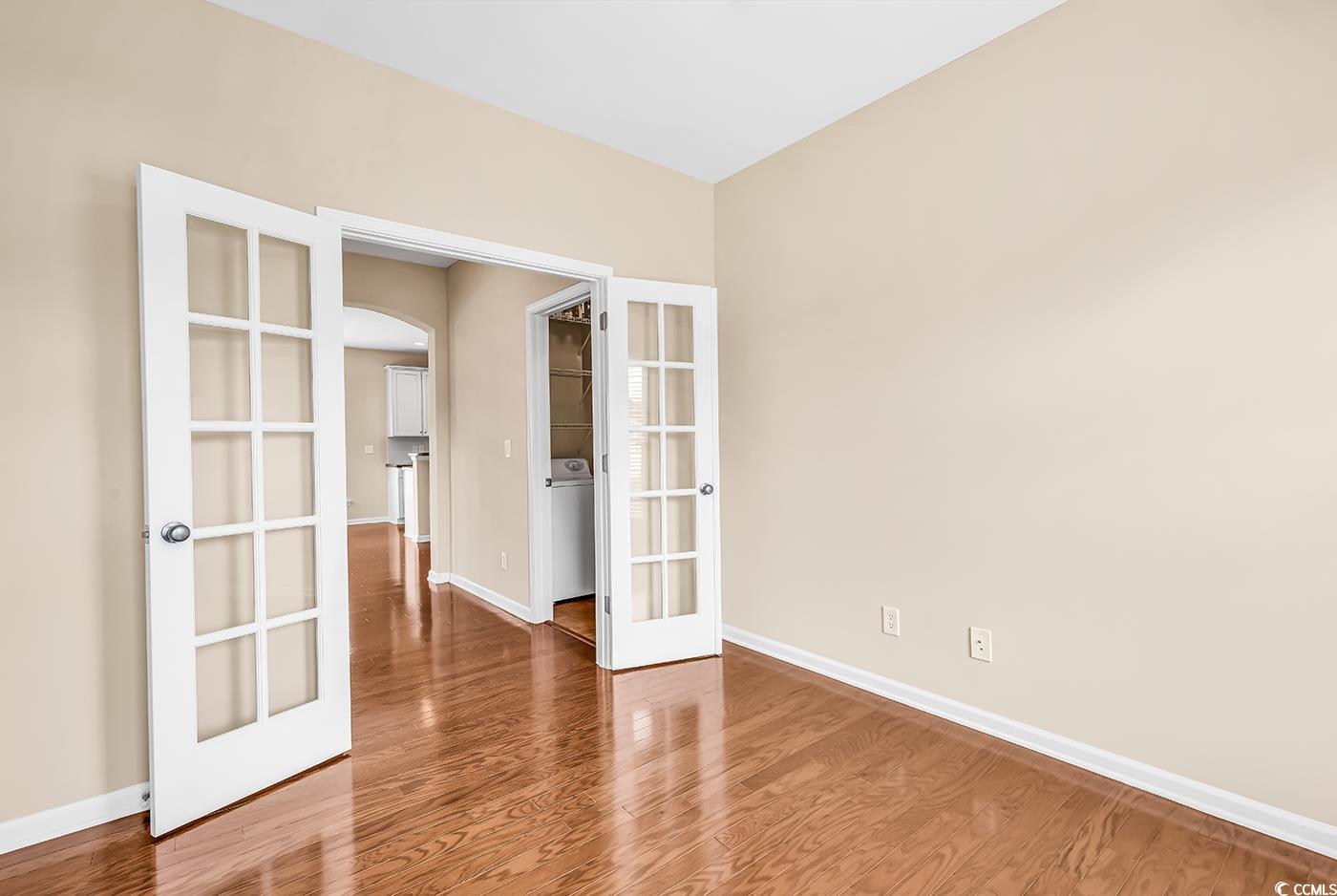 126 Dreamland Drive Murrells Inlet, SC 29576 - Photo 15 of 40 Unfurnished room with french doors, arched walkways, baseboards, and wood finished floors