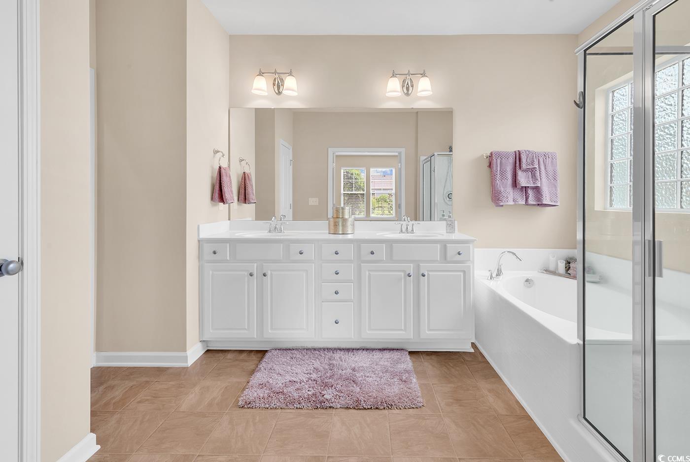 126 Dreamland Drive Murrells Inlet, SC 29576 - Photo 20 of 40 Bathroom featuring double vanity, a garden tub, a shower stall, and baseboards