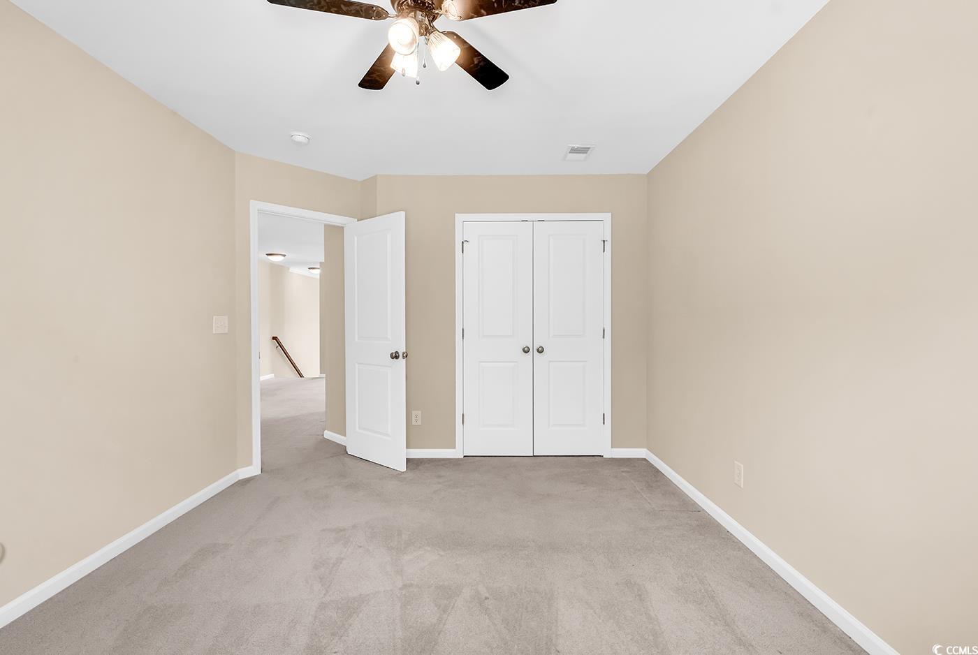 126 Dreamland Drive Murrells Inlet, SC 29576 - Photo 26 of 40 Unfurnished bedroom with light carpet, baseboards, a closet, and a ceiling fan