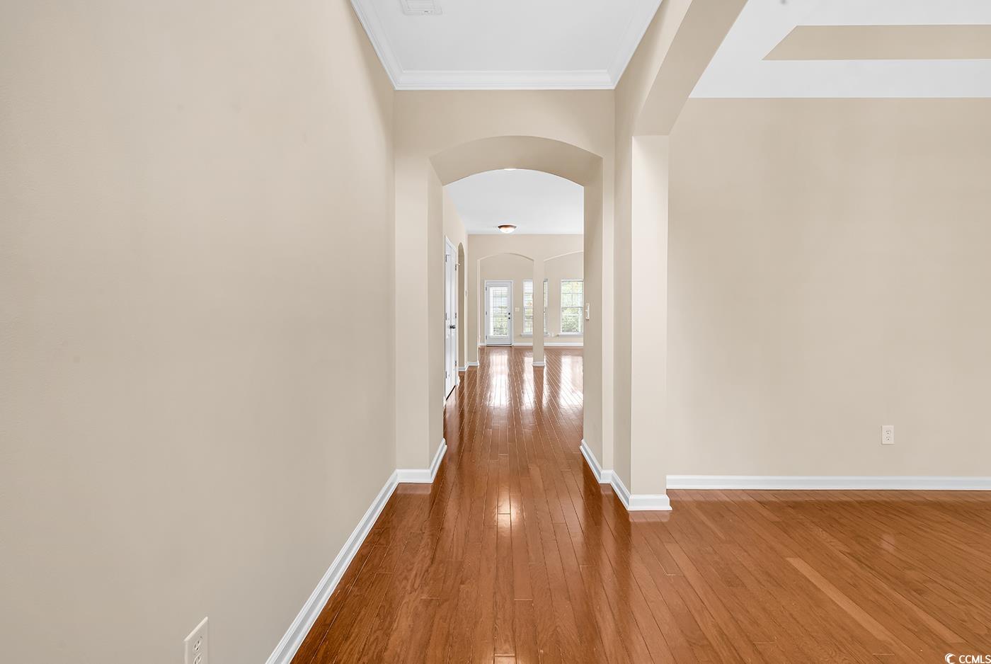 126 Dreamland Drive Murrells Inlet, SC 29576 - Photo 3 of 40 Hall with wood-type flooring, arched walkways, ornamental molding, and baseboards