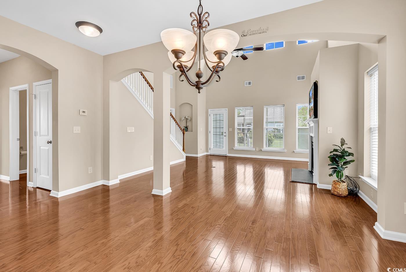 126 Dreamland Drive Murrells Inlet, SC 29576 - Photo 7 of 40 Unfurnished dining area featuring wood finished floors, arched walkways, stairs, and baseboards