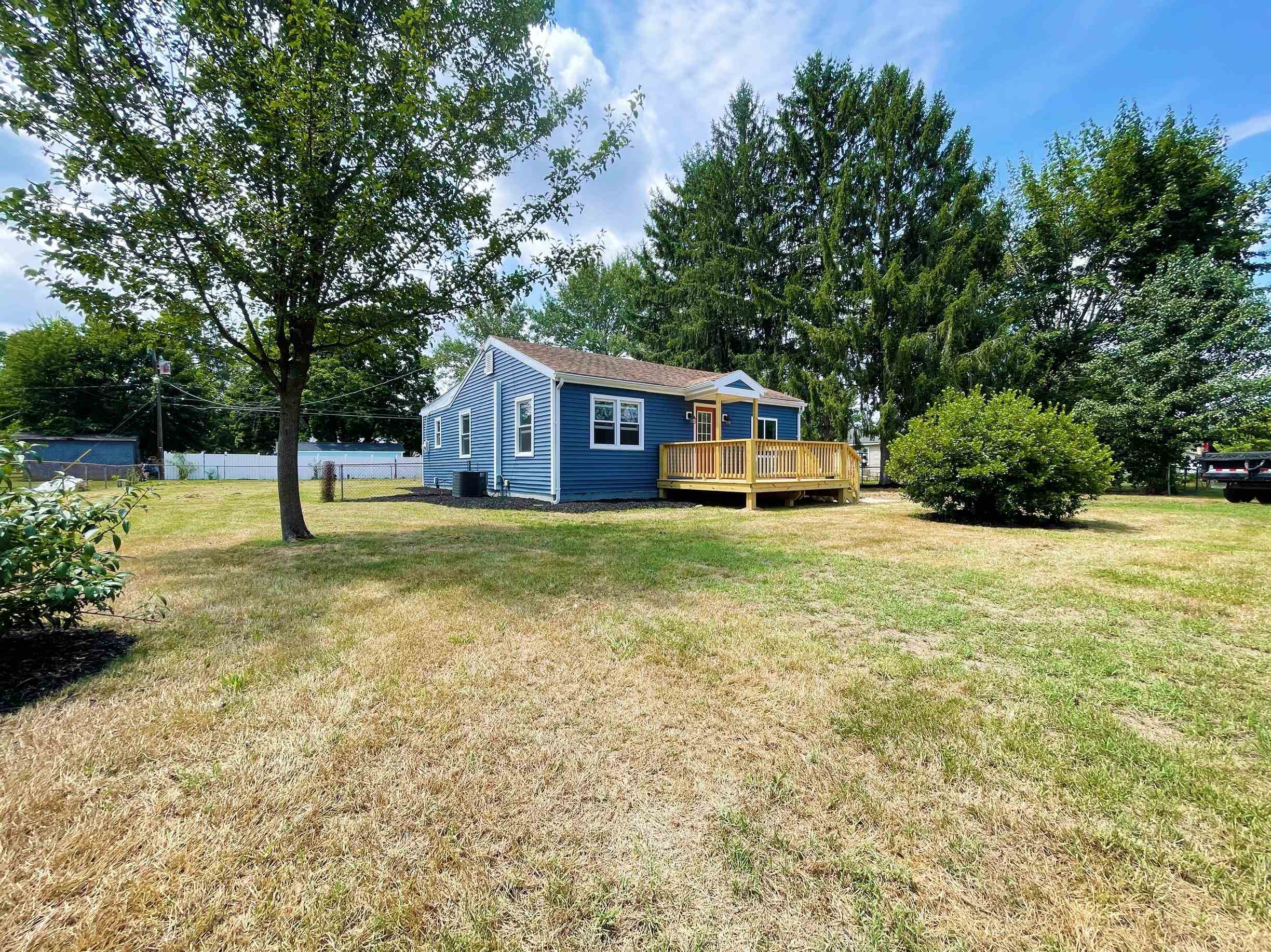 a view of a house with yard and sitting area