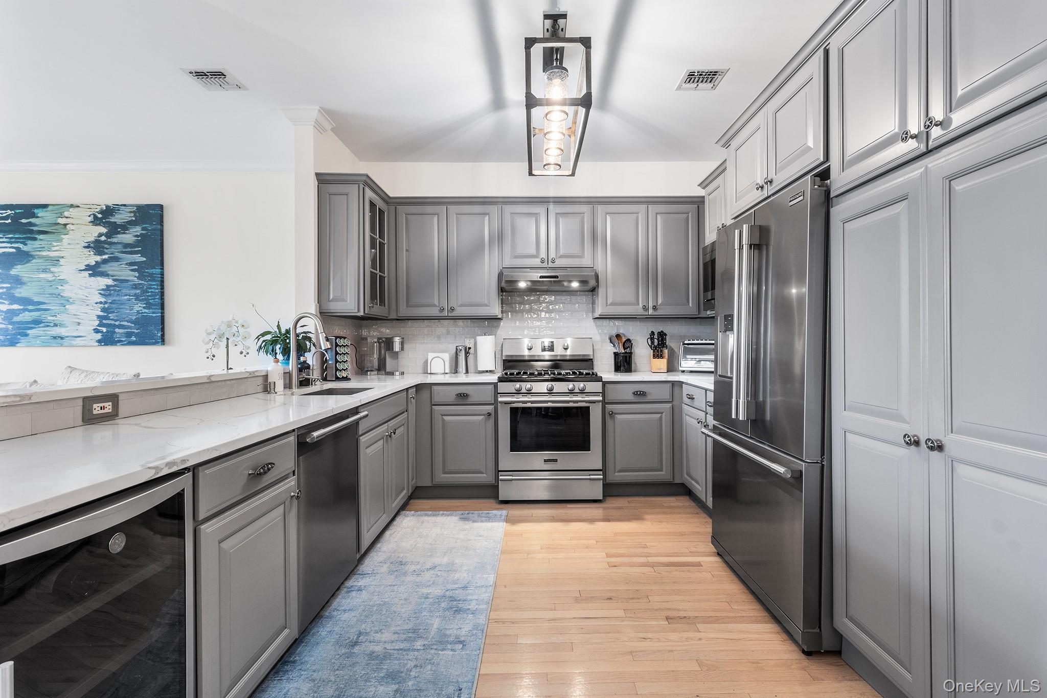 7 Salt Meadow Road, Unit 7 Babylon, NY 11702 - Photo 12 of 35 a kitchen with stainless steel appliances granite countertop a sink a stove a refrigerator cabinets and a window