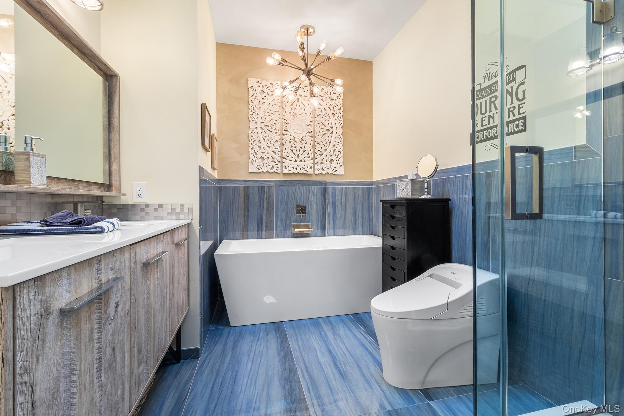 7 Salt Meadow Road, Unit 7 Babylon, NY 11702 - Photo 21 of 35 a bathroom with a double vanity sink a toilet a mirror and bathtub