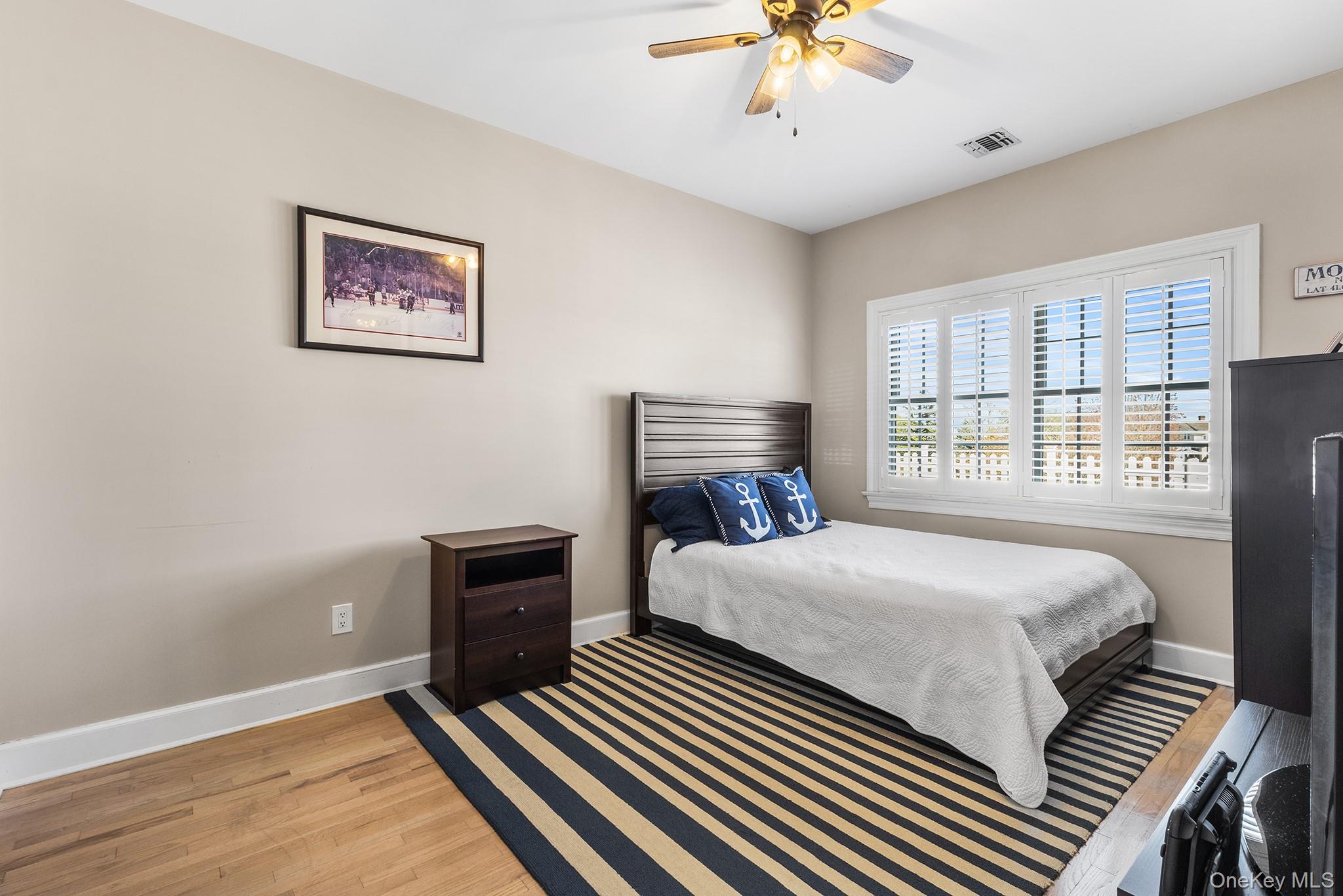 7 Salt Meadow Road, Unit 7 Babylon, NY 11702 - Photo 23 of 35 a bedroom with a bed and a window