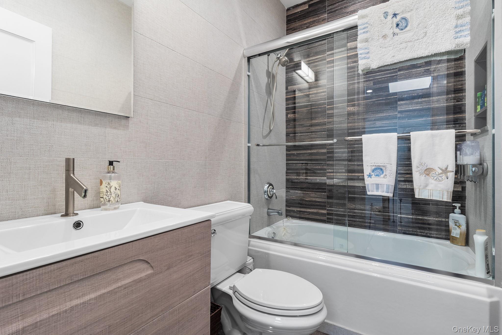 7 Salt Meadow Road, Unit 7 Babylon, NY 11702 - Photo 24 of 35 a bathroom with a sink a toilet and shower
