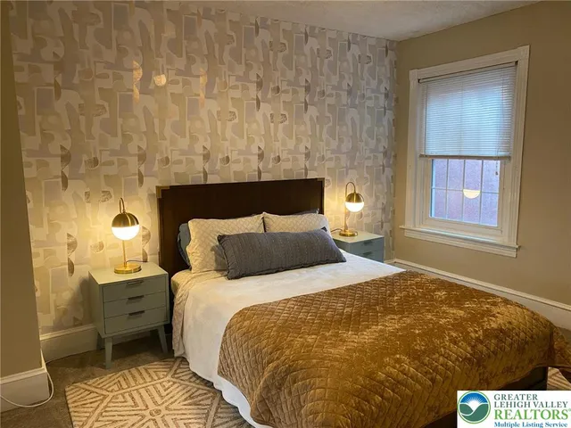 a bed sitting in a bedroom next to a bathroom