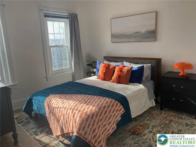 a bedroom with a bed and a painting on the wall