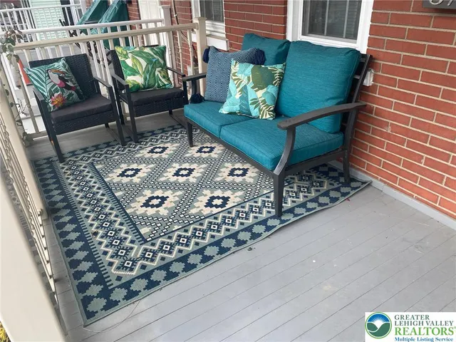 a outdoor living room with furniture and a rug