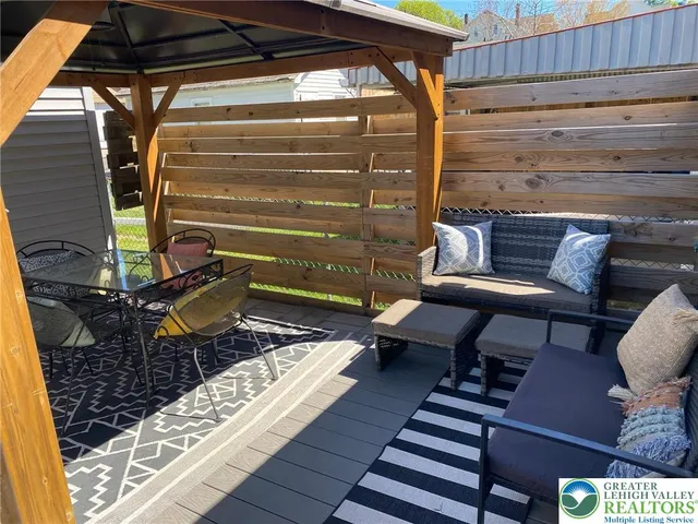 a roof deck with wooden floor and furniture