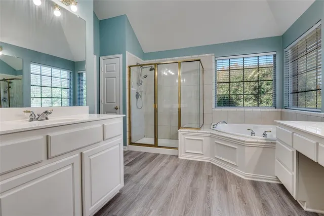 a bathroom with a tub sink shower and mirror