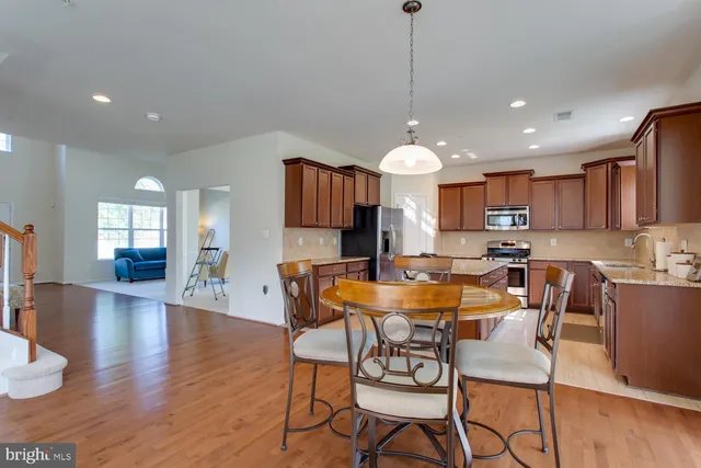 a view of a dining room and livingroom with furniture wooden floor a rug a fireplace