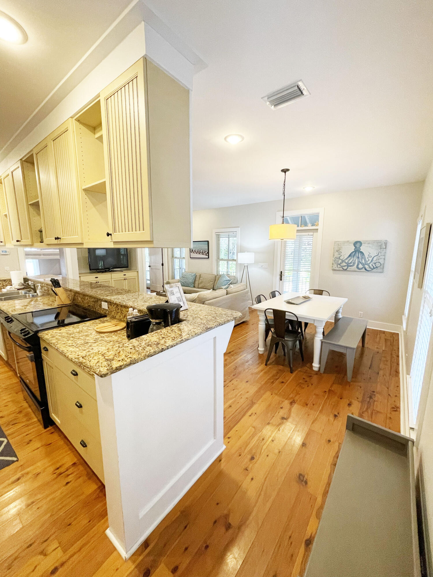 29 Olivia Lane Seacrest, FL 32461 - Photo 6 of 28 a kitchen with stainless steel appliances granite countertop sink stove and white cabinets with wooden floor
