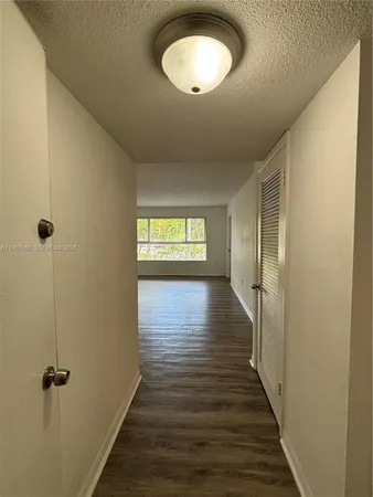 a view of a room with wooden floor and a window
