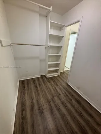 a view of walk in closet with empty racks