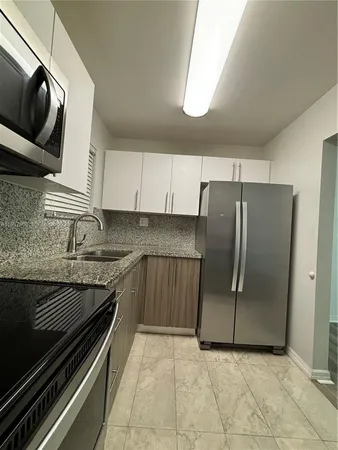 a kitchen with a refrigerator and a stove