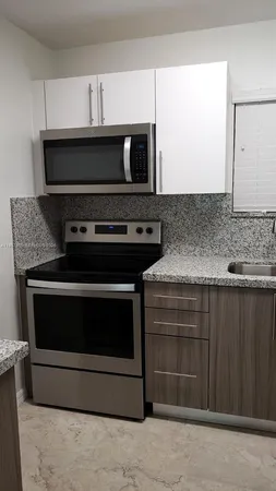a stove top oven sitting inside of a kitchen