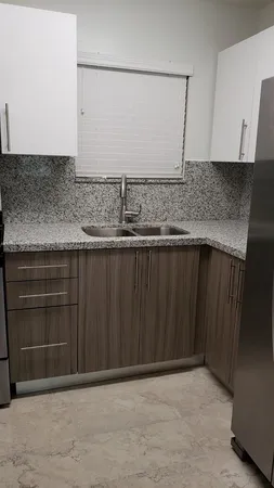 a bathroom with a granite countertop sink and cabinets