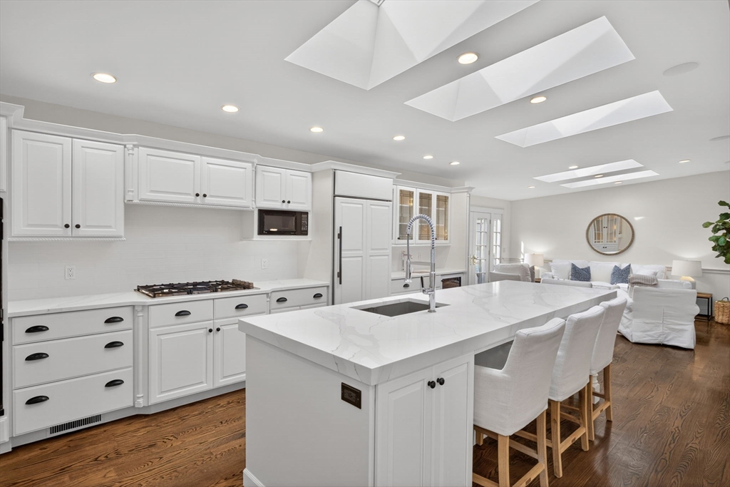 1114 Orleans Road, Unit 1 North Chatham, MA 02650 - Photo 8 of 42 a kitchen that has a lot of cabinets in it with granite countertop a sink a stove a dining table and chairs