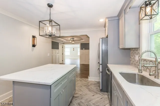 a kitchen with kitchen island stainless steel appliances a sink center island and stainless steel appliances