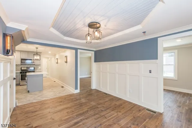 a view of a kitchen with wooden floor and a refrigerator