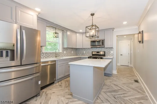 a kitchen with kitchen island granite countertop stainless steel appliances and a sink