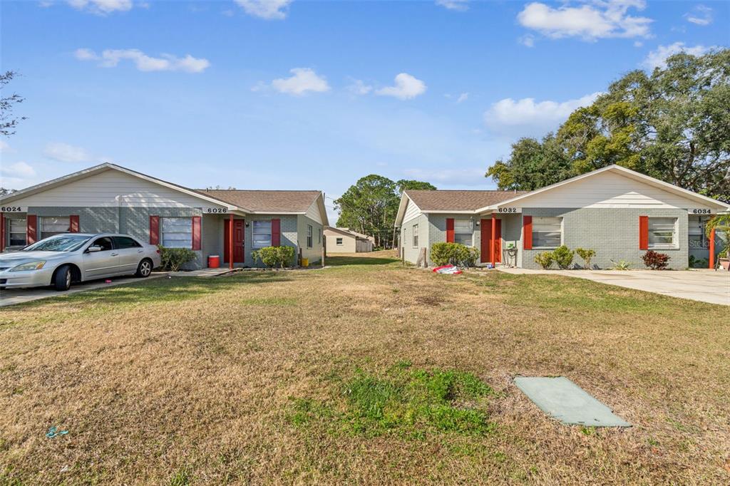 a front view of a house with a yard and car parked