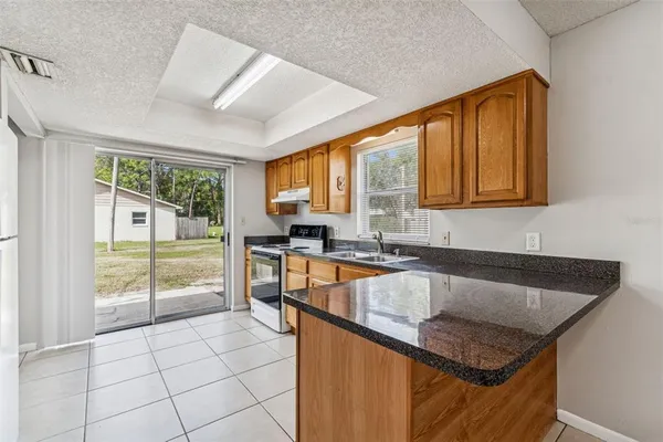 a kitchen that has a sink a table and chairs in it