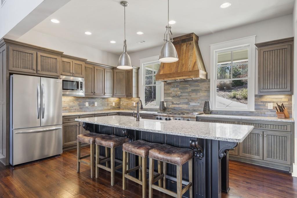 72 Buckeye Ridge Newnan, GA 30263 - Photo 17 of 80 a kitchen with wooden floor and stainless steel appliances