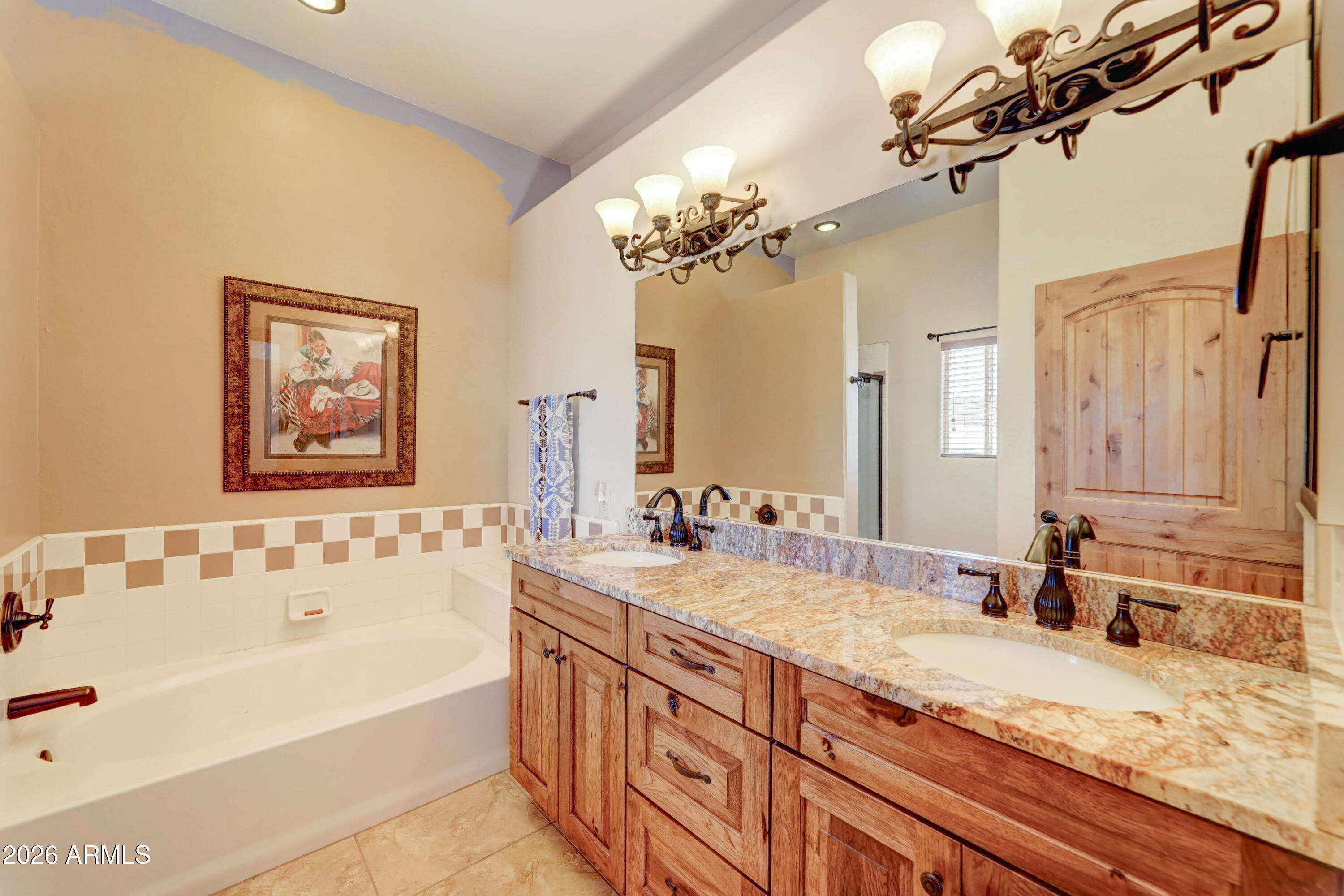 4642 North Tomahawk Road Apache Junction, AZ 85119 - Photo 16 of 41 a bathroom with a granite countertop sink a large mirror a shower and a bathtub