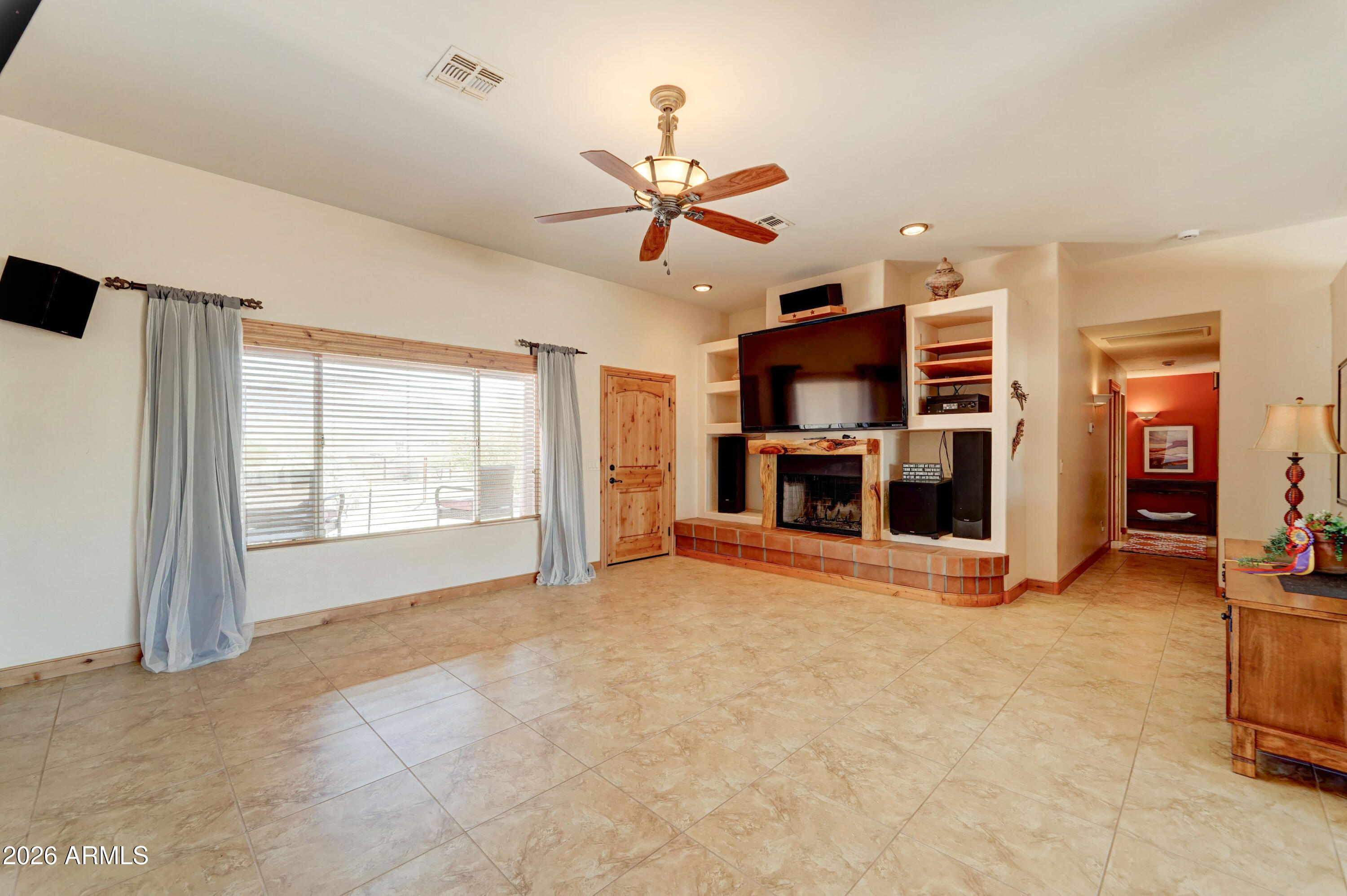 4642 North Tomahawk Road Apache Junction, AZ 85119 - Photo 7 of 41 a view of a livingroom with a fireplace a ceiling fan and windows