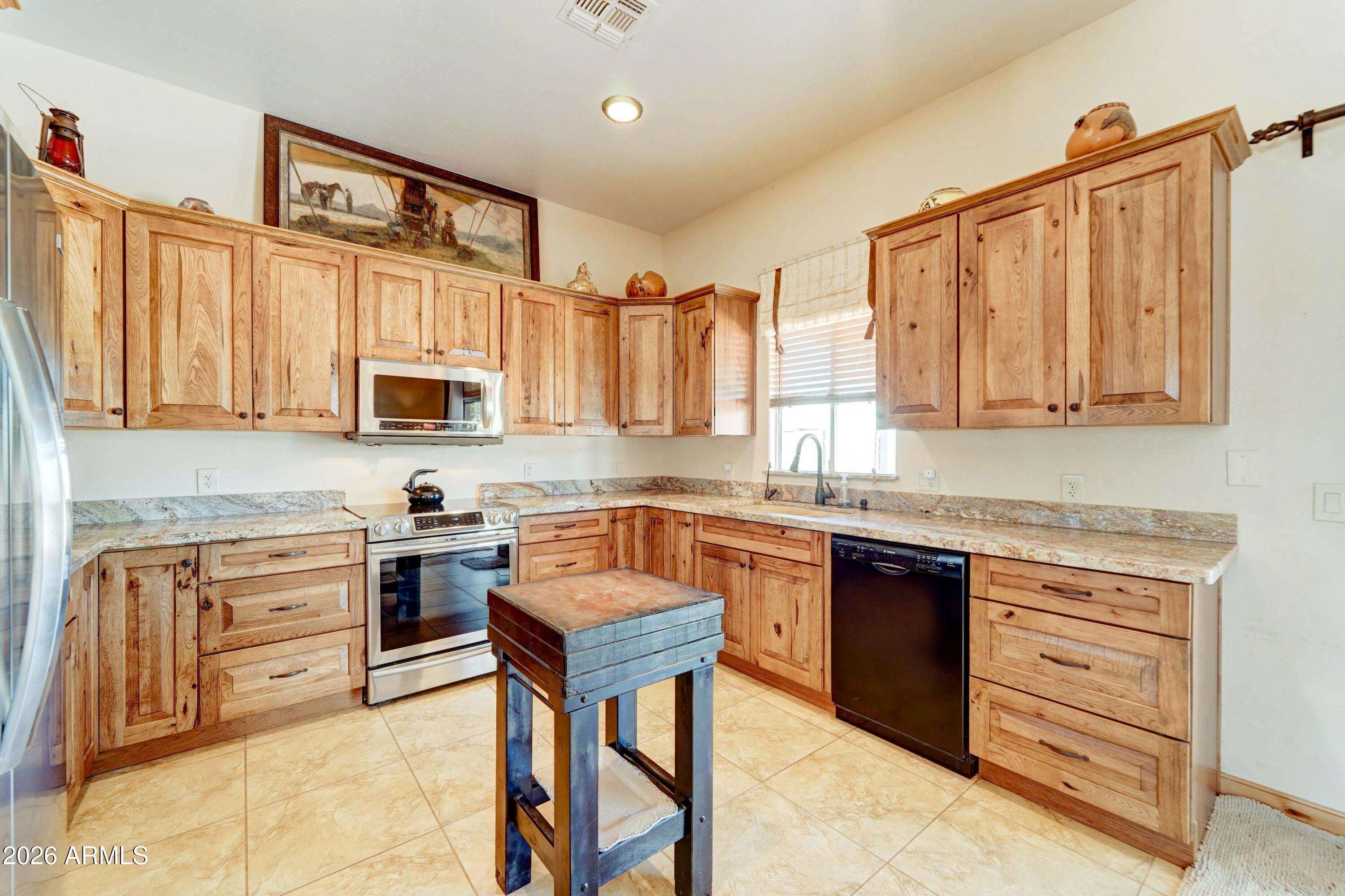 4642 North Tomahawk Road Apache Junction, AZ 85119 - Photo 9 of 41 a kitchen with stainless steel appliances granite countertop a stove sink and cabinets
