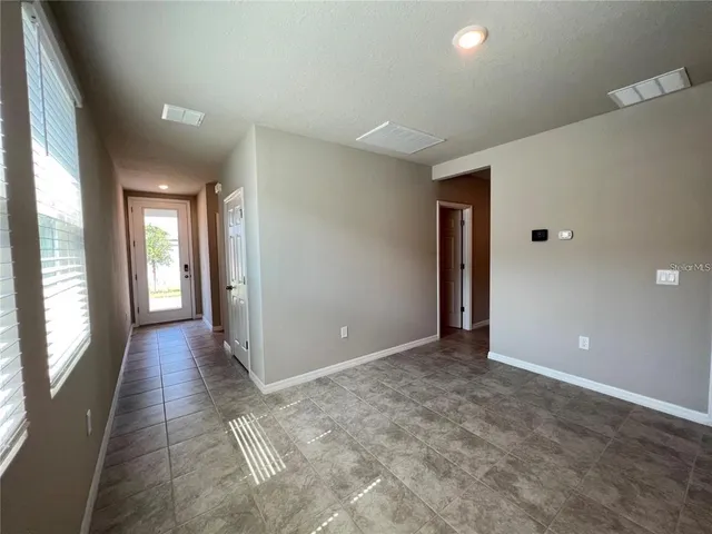 a view of a hallway with wooden floor and windows