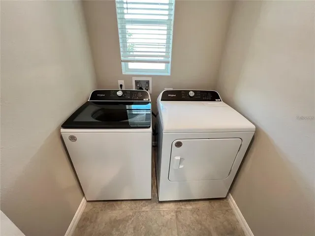 a utility room with wooden floor washer and dryer