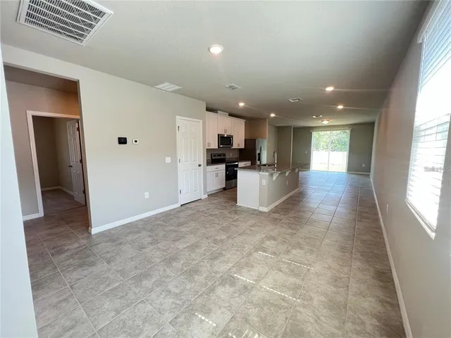 a view of a kitchen with kitchen island stainless steel appliances refrigerator sink microwave and cabinets