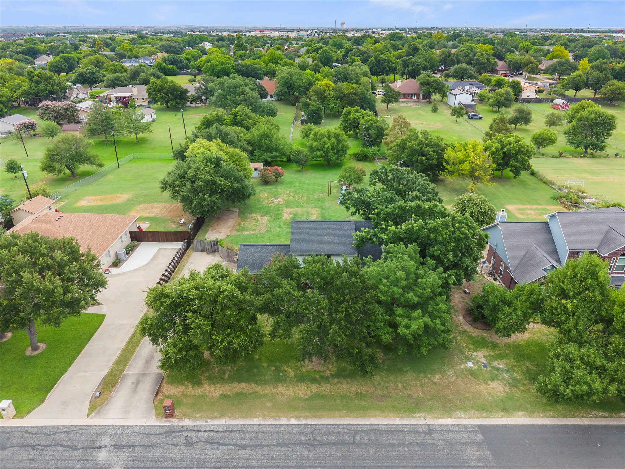 1329 Quail Ravine Round Rock, TX 78664 - Photo 4 of 39 An aerial view showcases a spacious green lot nestled within a peaceful residential neighborhood.