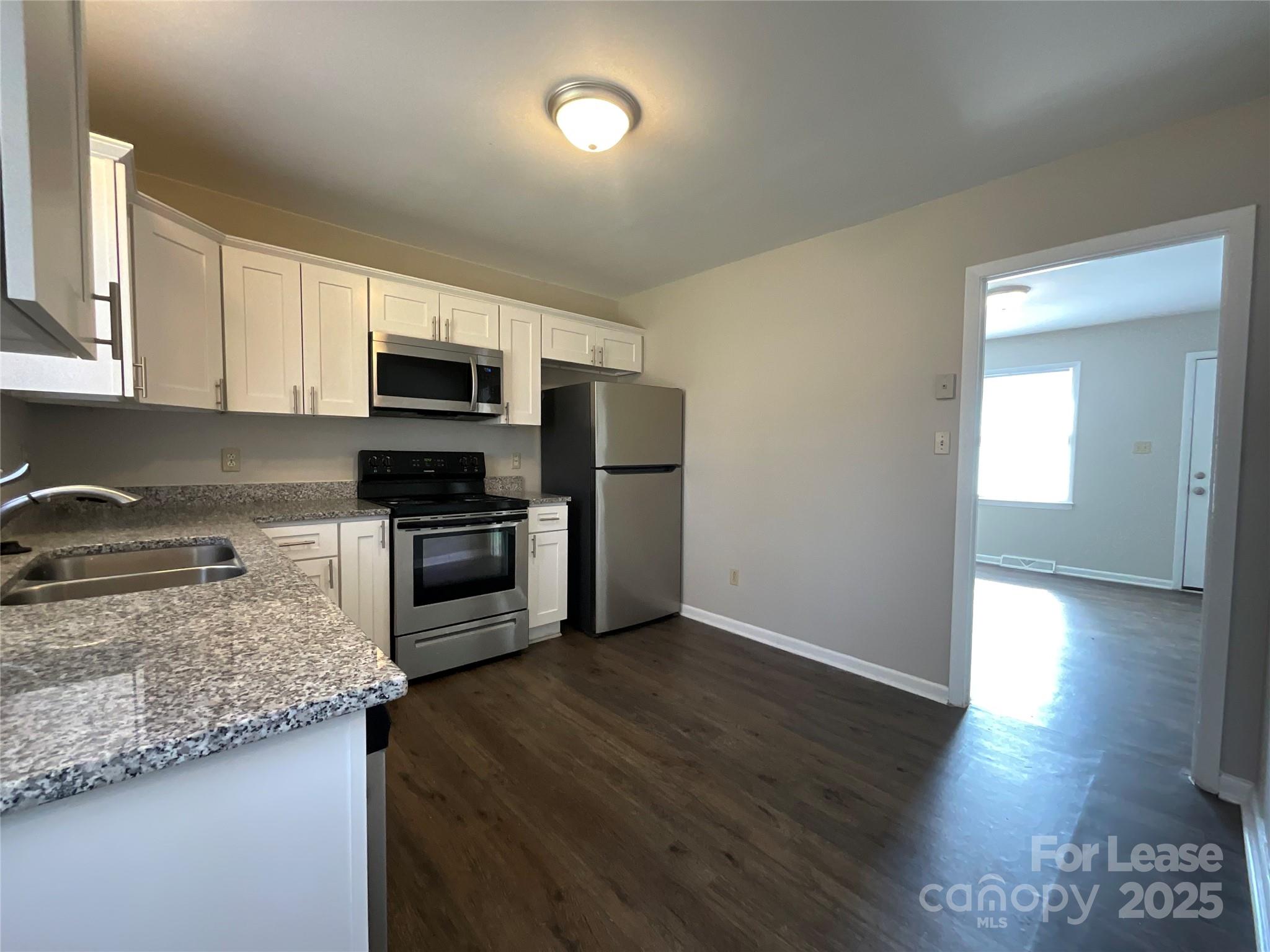 2002 Airport Road, Unit B Salisbury, NC 28147 - Photo 5 of 13 a kitchen with granite countertop a refrigerator and a stove top oven