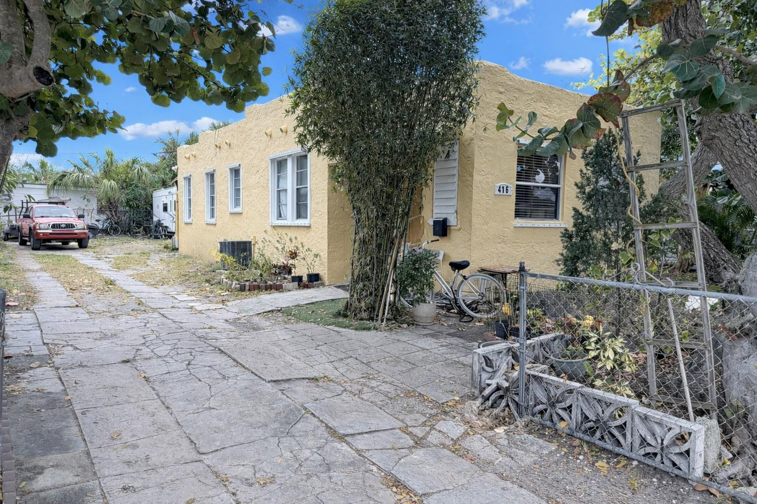 a row of palm trees in front of a house
