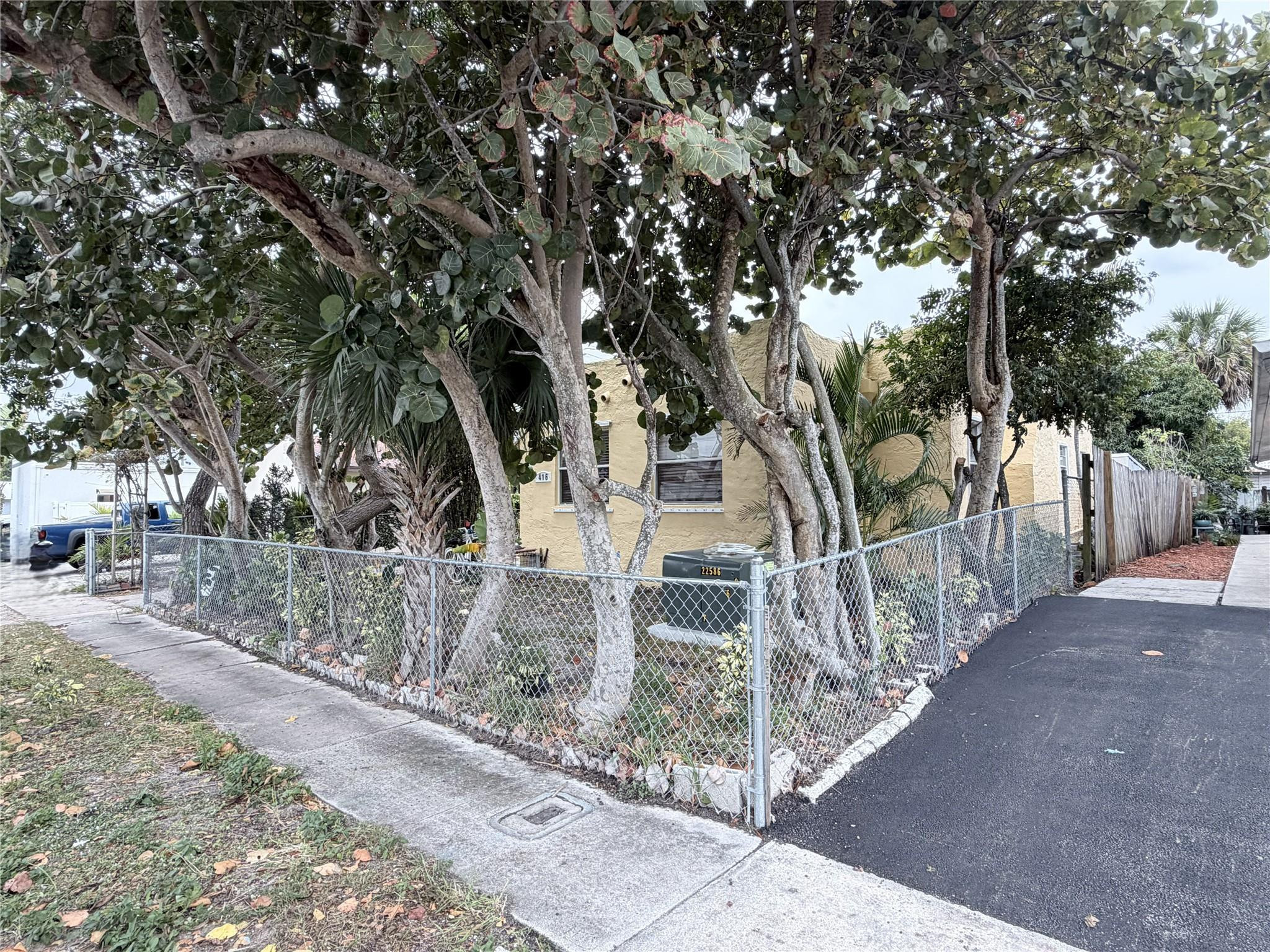 416 Revere Road West Palm Beach, FL 33405 - Photo 2 of 9 a view of house with large tree and wooden fence