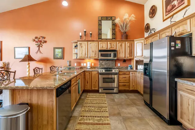 a kitchen with stainless steel appliances granite countertop a stove a sink and a microwave