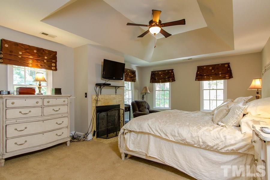 6324 Battleview Drive Raleigh, NC 27613 - Photo 15 of 25 a bedroom with a bed a flat screen tv and a chandelier