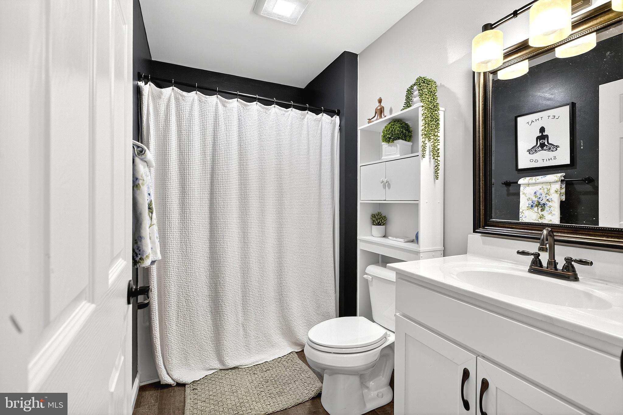 108 West Commerce Street Kenton, DE 19938 - Photo 35 of 48 a bathroom with a sink a toilet and shower curtain