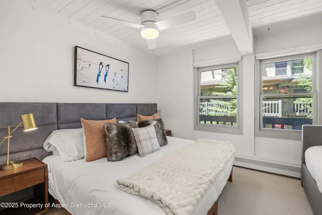 a large bed sitting in a bedroom next to a window